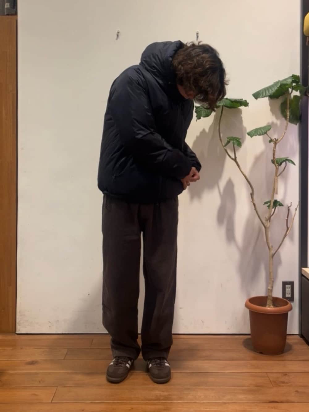 ブラウン系のニット/セーター、ブルー系のダウンジャケット/コート、ブラウン系のその他パンツを着用したメンズの冬コーディネートの4枚目の写真