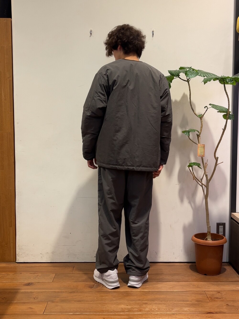 ブラウン系のニット/セーター、グレー系のダウンジャケット/コート、グレー系のその他パンツを着用したメンズの秋コーディネートの3枚目の写真