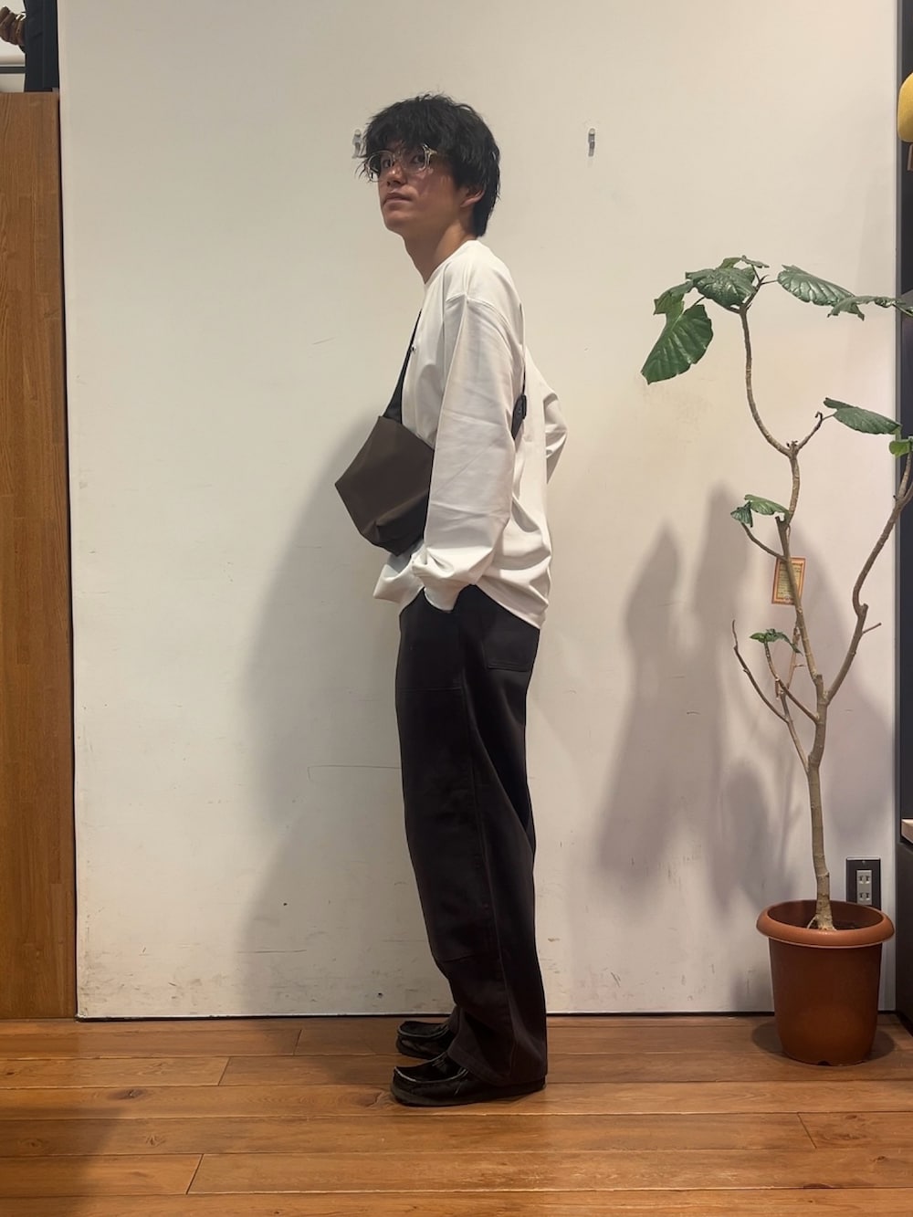 ホワイト系のTシャツ/カットソー、ブラウン系のショルダーバッグ、グレー系のその他パンツを着用したメンズの秋コーディネートの2枚目の写真