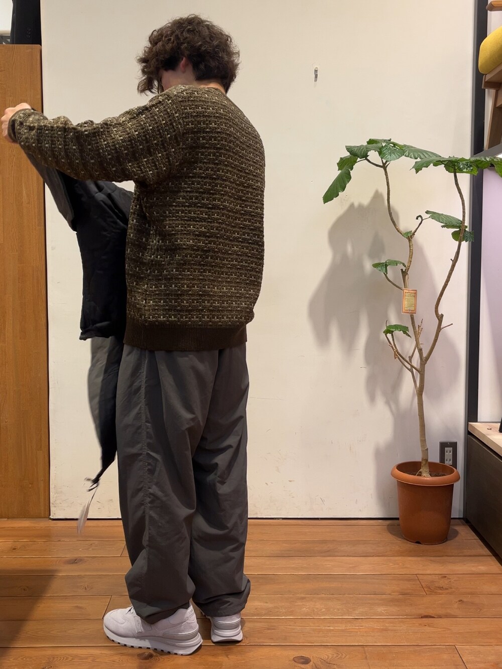 ブラウン系のニット/セーター、グレー系のダウンジャケット/コート、グレー系のその他パンツを着用したメンズの秋コーディネートの5枚目の写真
