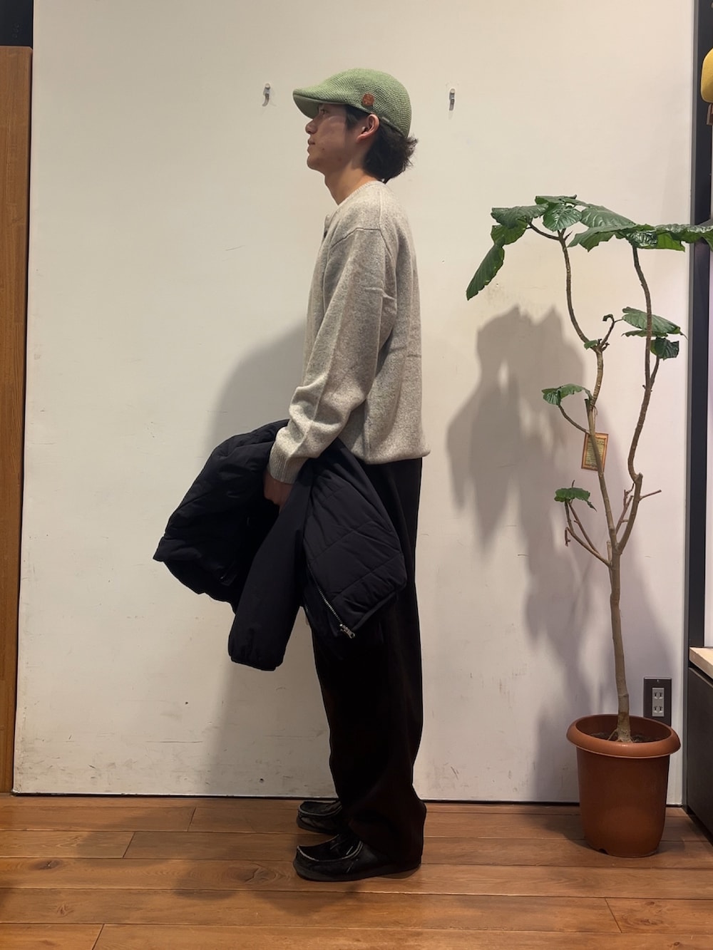 グレー系のニット/セーター、ブラック系のその他アウター、ブラウン系のその他パンツを着用したメンズの秋コーディネートの2枚目の写真