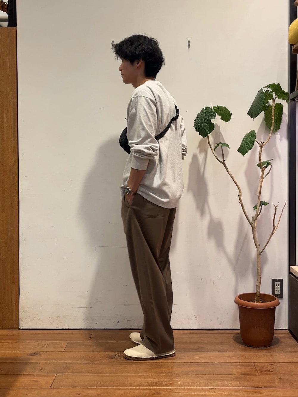 グレー系のTシャツ/カットソー、ブラック系のショルダーバッグ、ベージュ系のその他パンツを着用したメンズの秋コーディネートの2枚目の写真