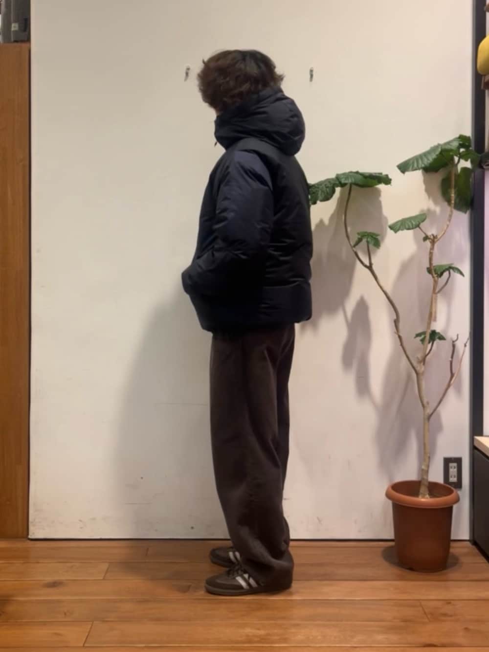 ブラウン系のニット/セーター、ブルー系のダウンジャケット/コート、ブラウン系のその他パンツを着用したメンズの冬コーディネートの2枚目の写真