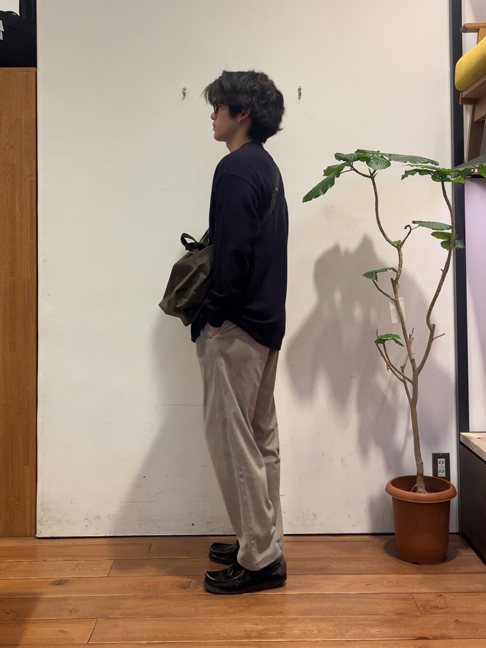 ベージュ系のその他パンツ、グレー系のTシャツ/カットソー、グリーン系のショルダーバッグを着用したメンズの秋コーディネートの2枚目の写真