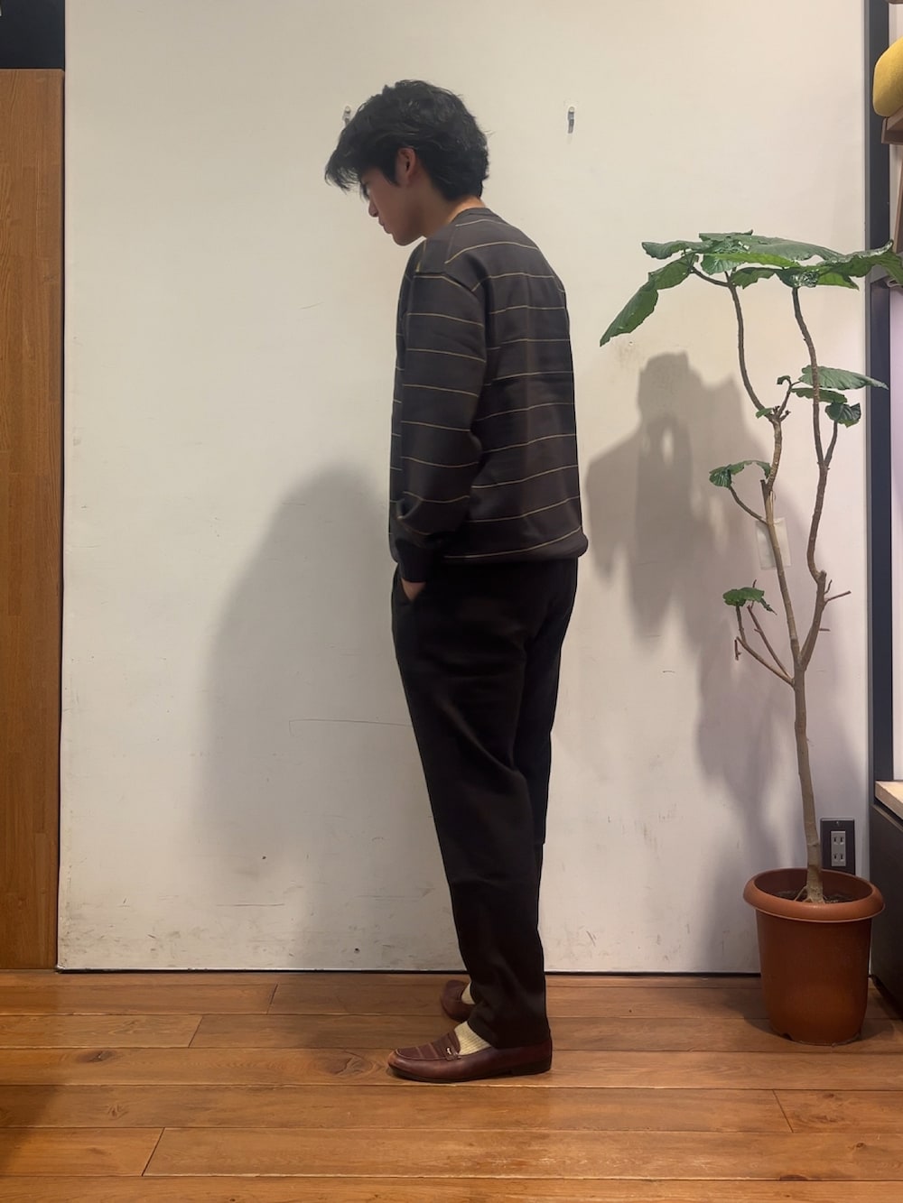 グレー系のニット/セーター、ブラウン系のその他パンツを着用したメンズの秋コーディネートの2枚目の写真