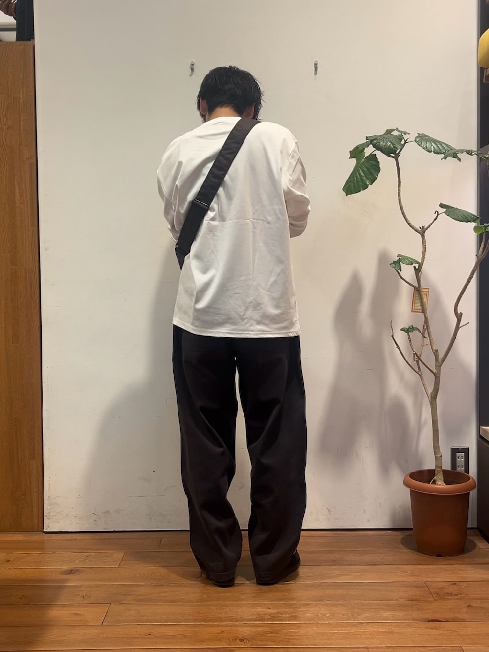 ホワイト系のTシャツ/カットソー、ブラウン系のショルダーバッグ、グレー系のその他パンツを着用したメンズの秋コーディネートの3枚目の写真
