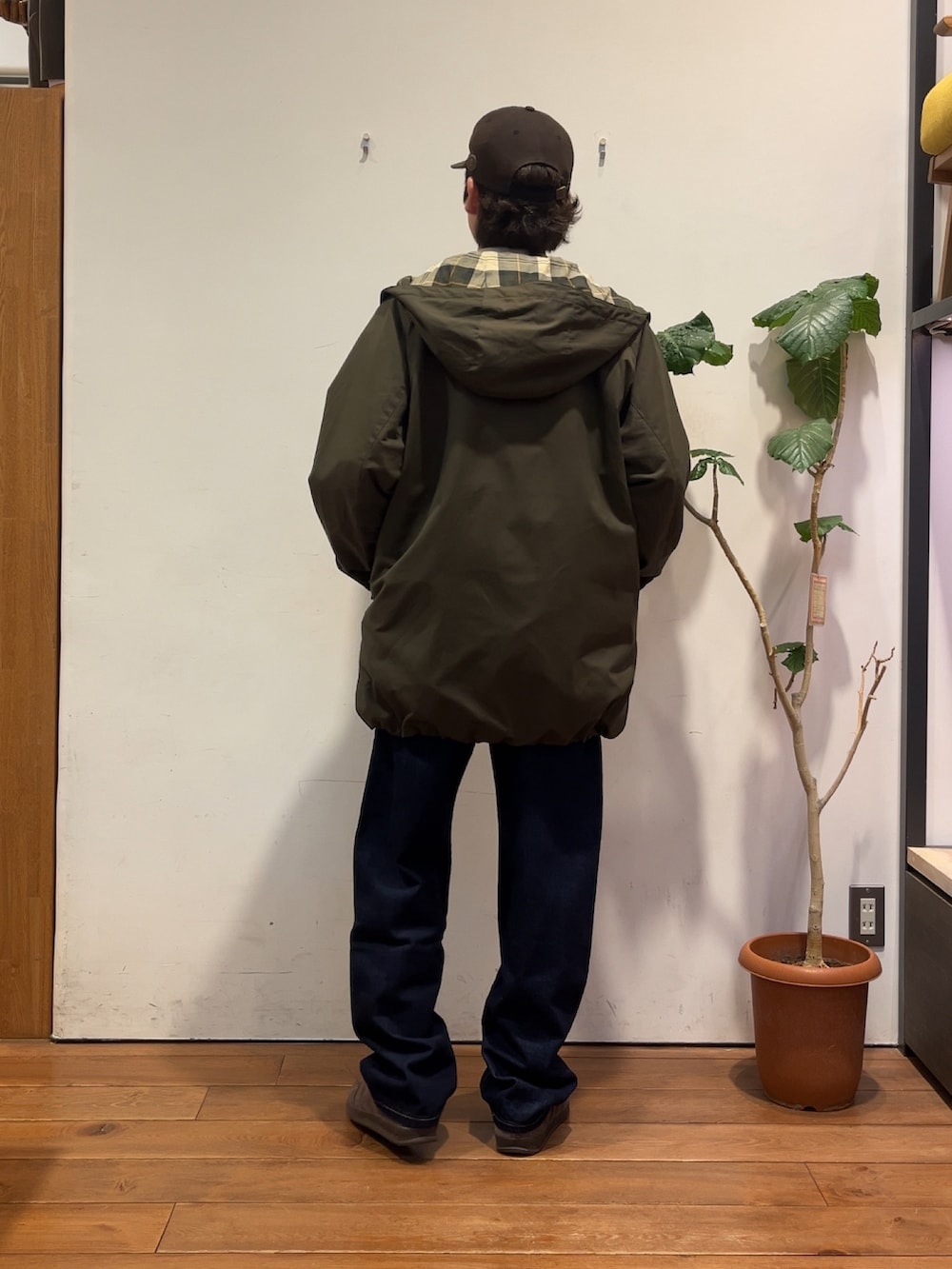 グレー系のスウェット、グリーン系のその他アウター、ブルー系のデニムパンツを着用したメンズの秋コーディネートの3枚目の写真