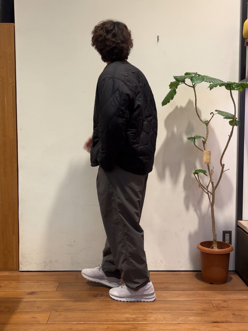 ブラウン系のニット/セーター、グレー系のダウンジャケット/コート、グレー系のその他パンツを着用したメンズの秋コーディネートの4枚目の写真
