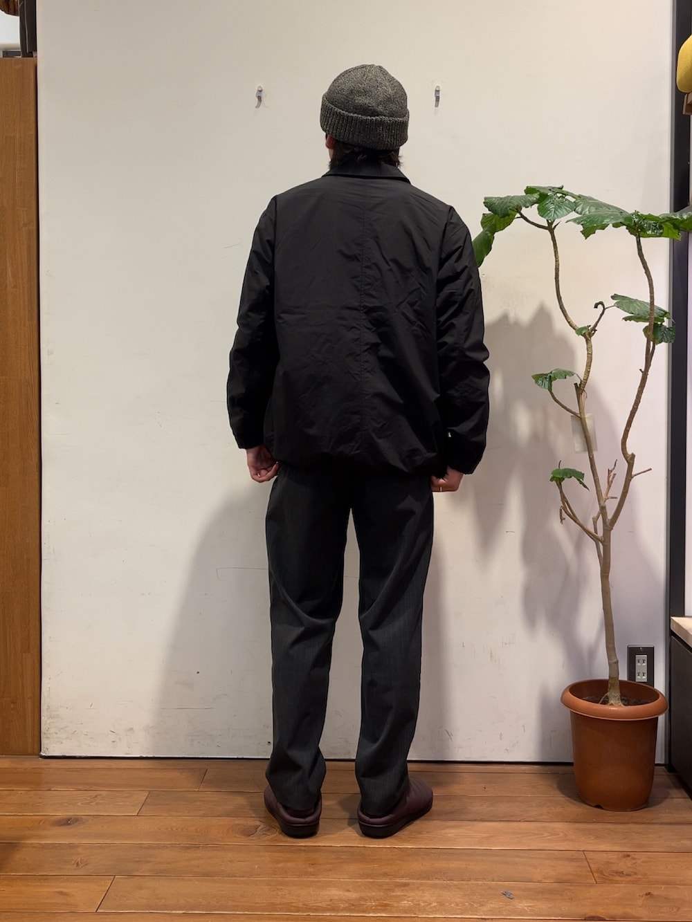 グレー系のニット/セーター、ブラック系のナイロンジャケット、グレー系のその他パンツを着用したメンズの秋コーディネートの3枚目の写真