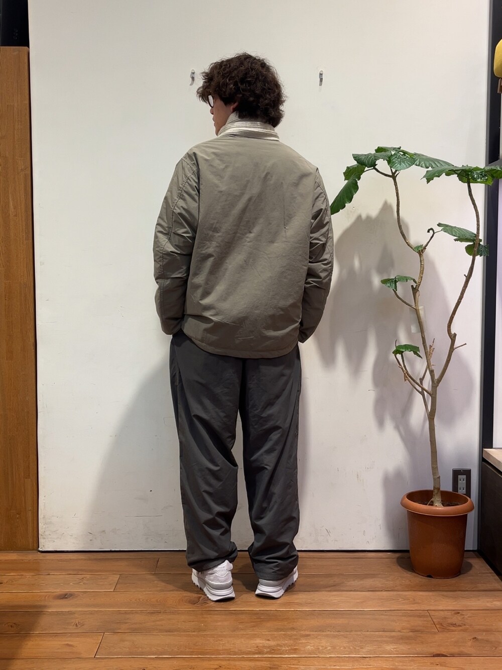 グレー系のその他パンツ、ベージュ系のダウンジャケット/コート、グレー系のスニーカーを着用したメンズの秋コーディネートの3枚目の写真