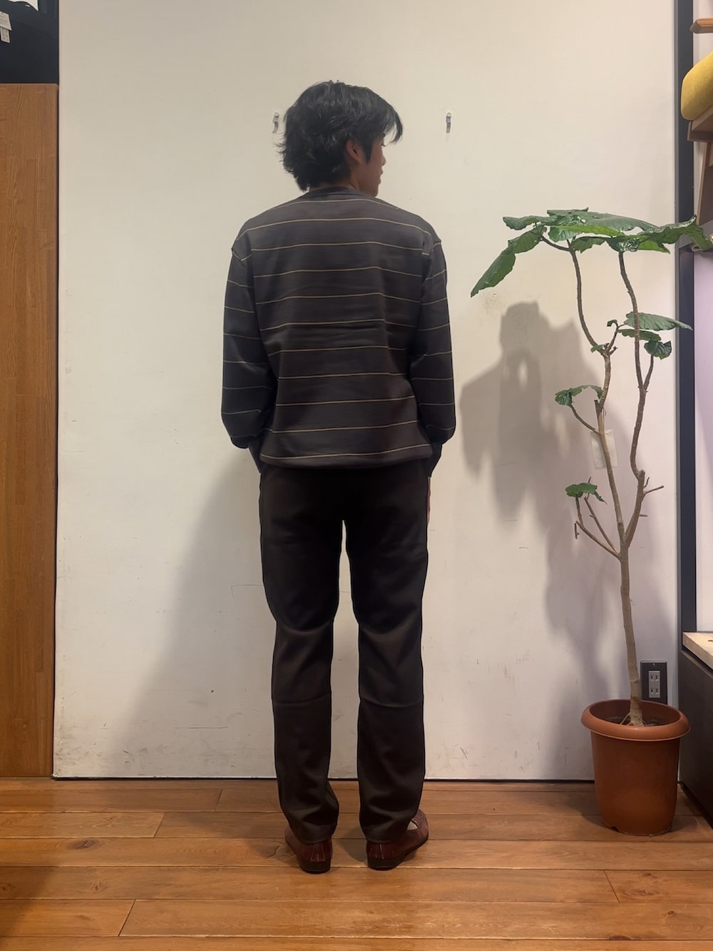 グレー系のニット/セーター、ブラウン系のその他パンツを着用したメンズの秋コーディネートの3枚目の写真