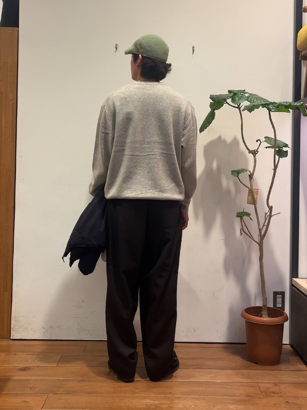 グレー系のニット/セーター、ブラック系のその他アウター、ブラウン系のその他パンツを着用したメンズの秋コーディネートの3枚目の写真