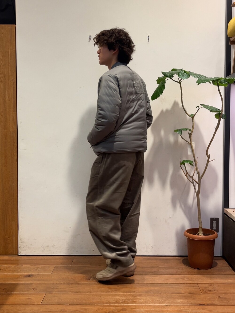 ブラウン系のその他パンツ、グレー系のダウンジャケット/コート、グリーン系のポロシャツを着用したメンズの秋コーディネートの2枚目の写真