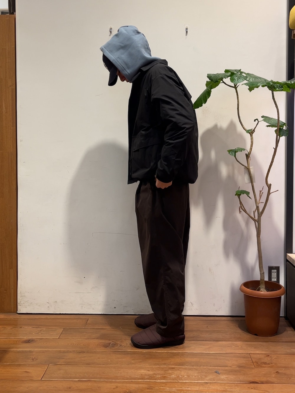 ブラウン系のその他パンツ、ブルー系のパーカー、ブラック系のナイロンジャケットを着用したメンズの冬コーディネートの2枚目の写真