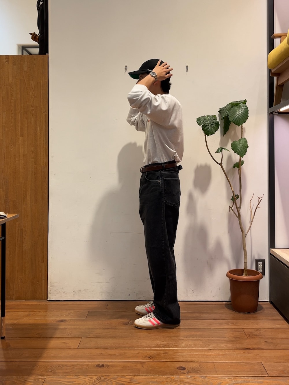 ベージュ系のスニーカー、ホワイト系のスウェット、ブラック系のキャップを着用したメンズの夏コーディネートの3枚目の写真