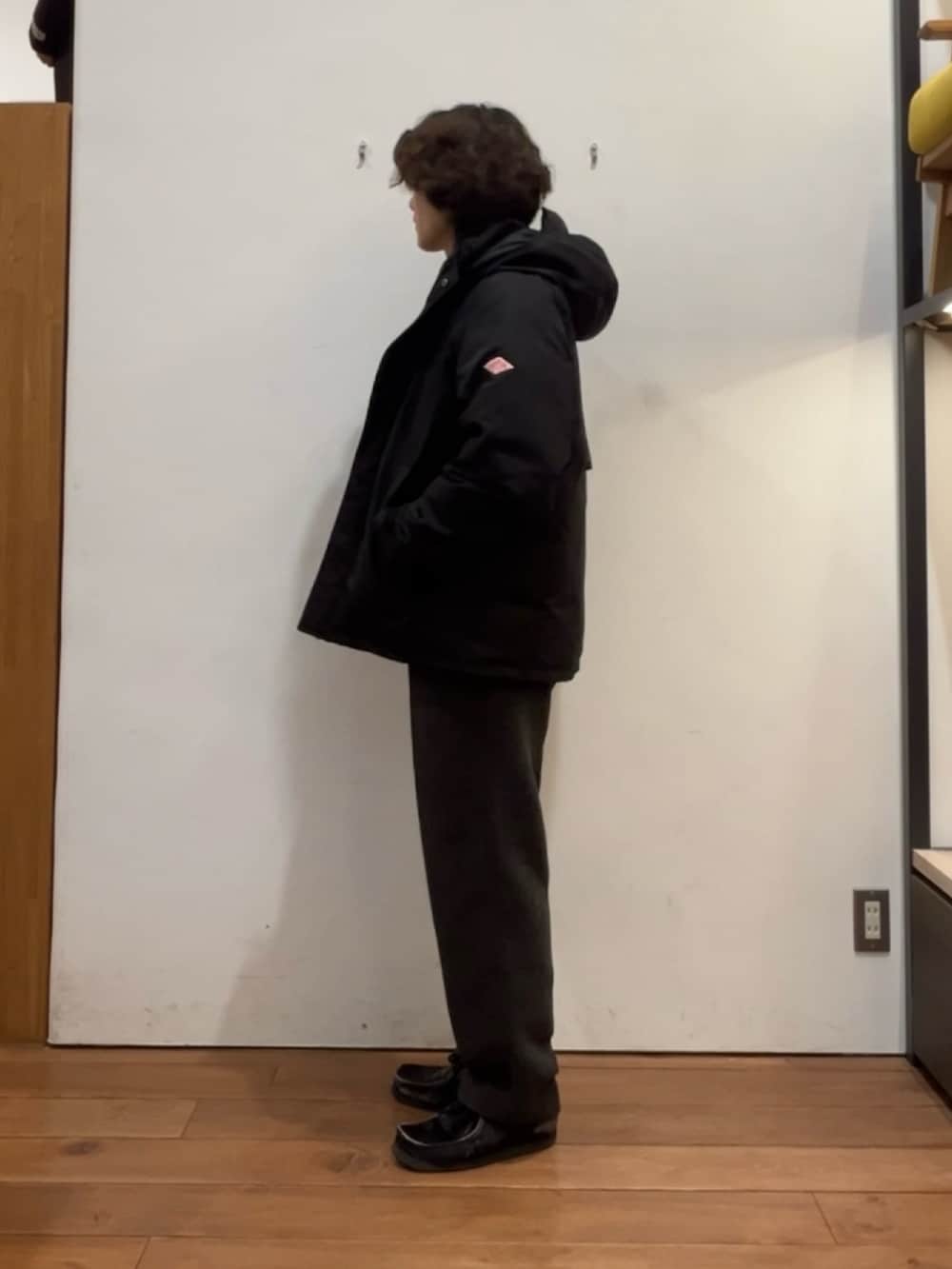 ブラック系のその他アウター、ブラウン系のポロシャツ、グレー系のその他パンツを着用したメンズの冬コーディネートの2枚目の写真