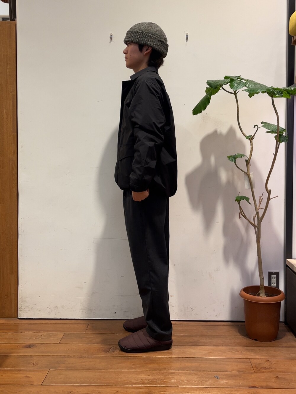 グレー系のニット/セーター、ブラック系のナイロンジャケット、グレー系のその他パンツを着用したメンズの秋コーディネートの2枚目の写真