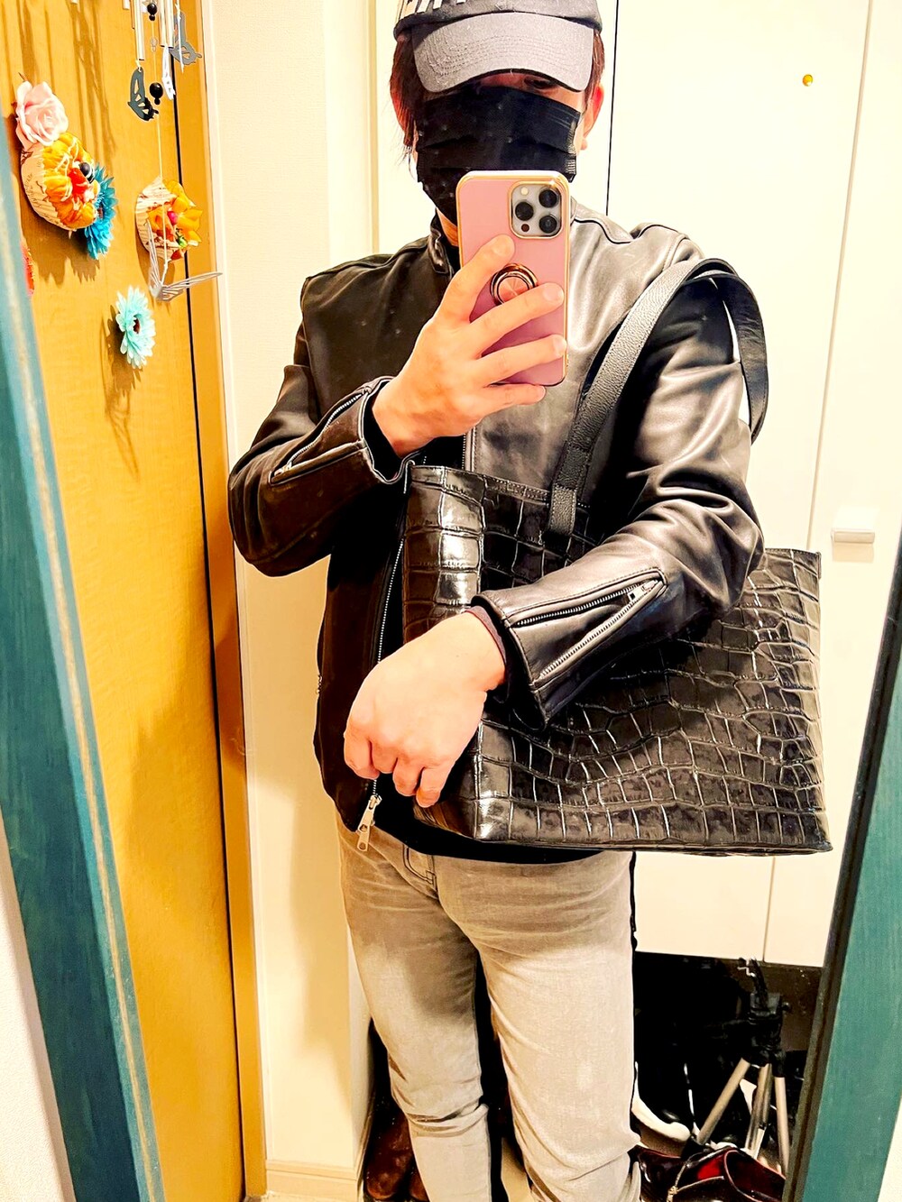 ブラック系のライダースジャケット、ブラック系のトートバッグを着用したメンズの春コーディネートの2枚目の写真