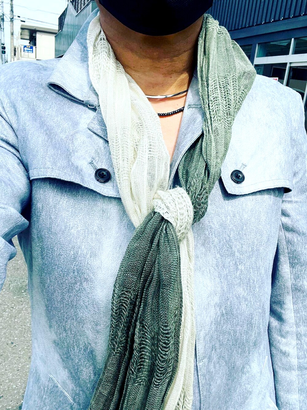 ブラック系のトートバッグ、ブラック系のデニムパンツ、ホワイト系のトレンチコートを着用したメンズの春コーディネートの2枚目の写真