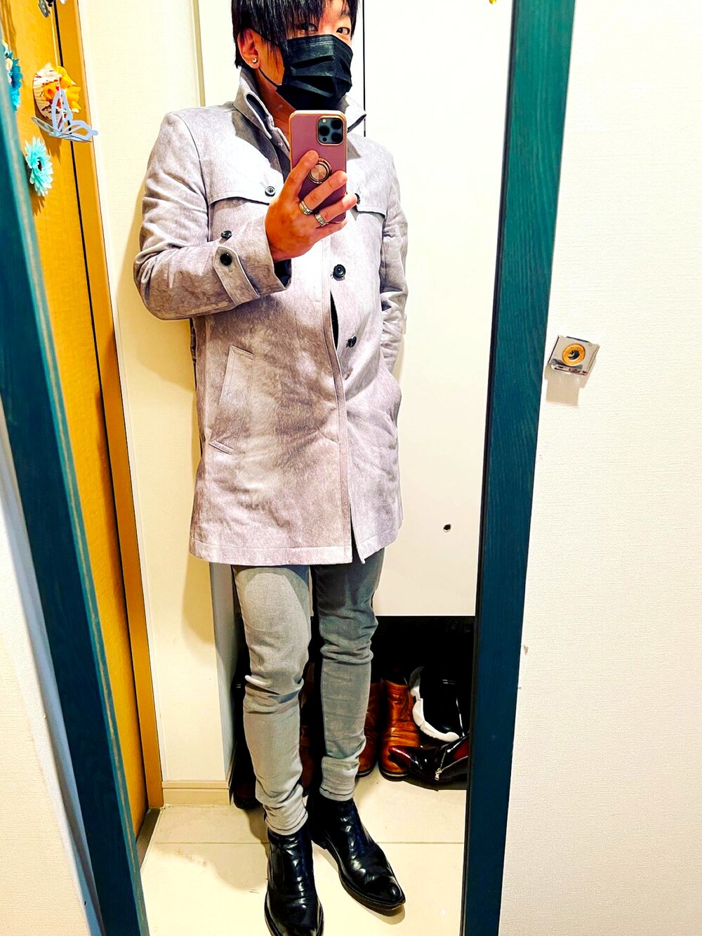 ブラック系のトートバッグ、ブラック系のデニムパンツ、ホワイト系のトレンチコートを着用したメンズの春コーディネートの3枚目の写真