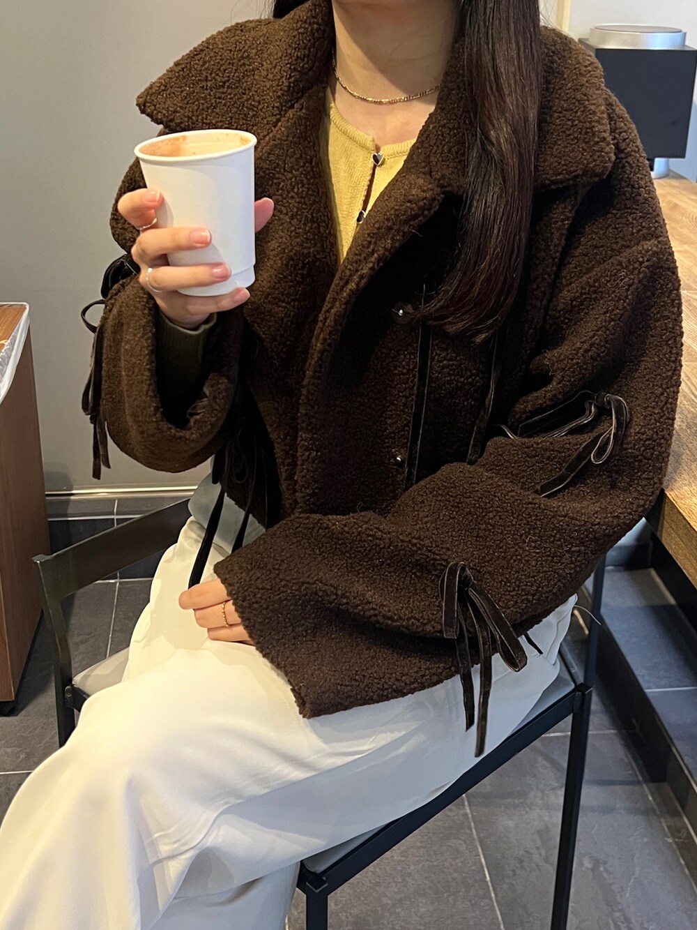 ブラウン系のブルゾンを着用したレディースの秋コーディネートの2枚目の写真