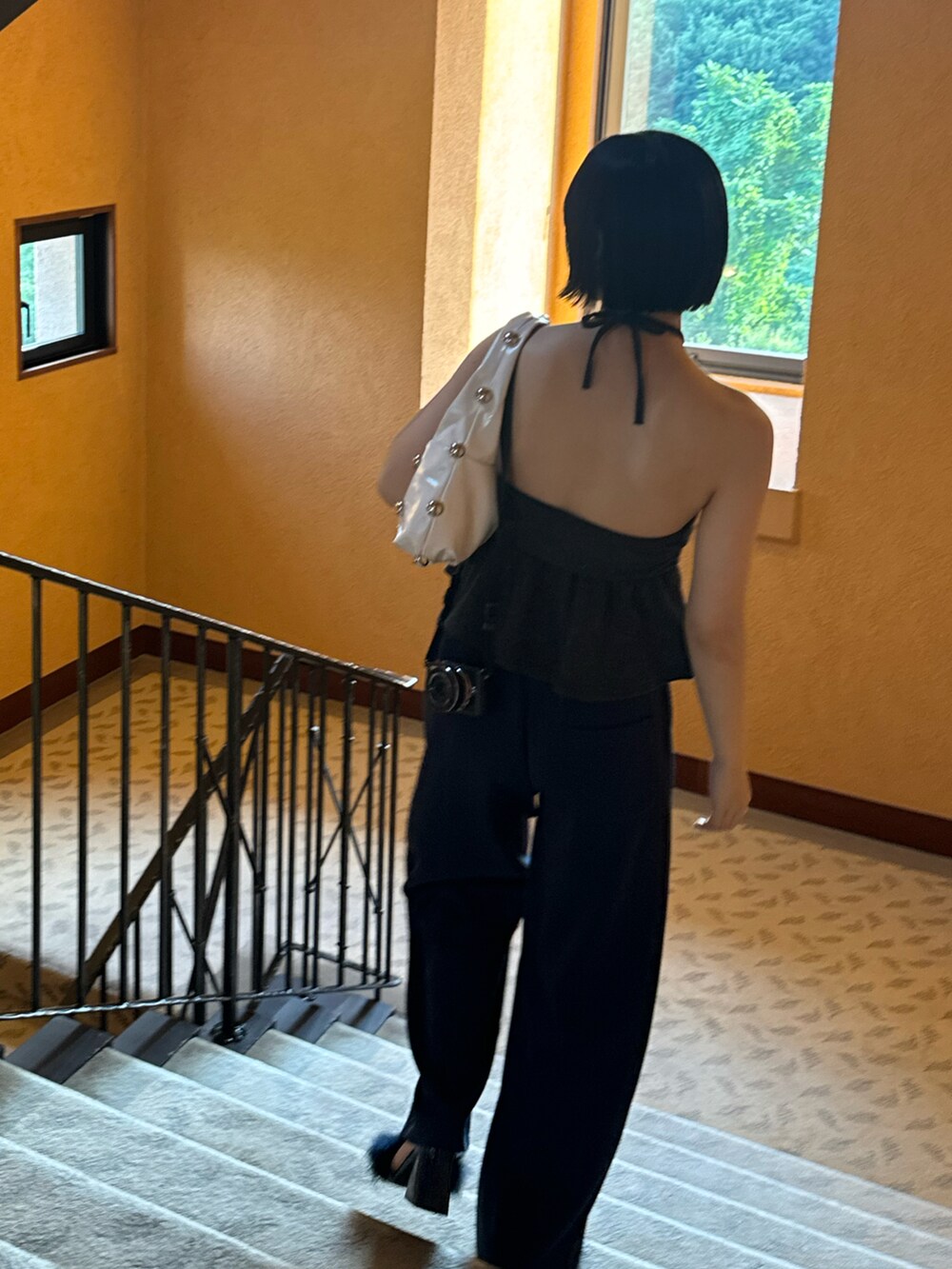 ブルー系のスウェットパンツ、ブラック系のチューブトップ、ホワイト系のハンドバッグを着用したレディースの夏コーディネートの4枚目の写真
