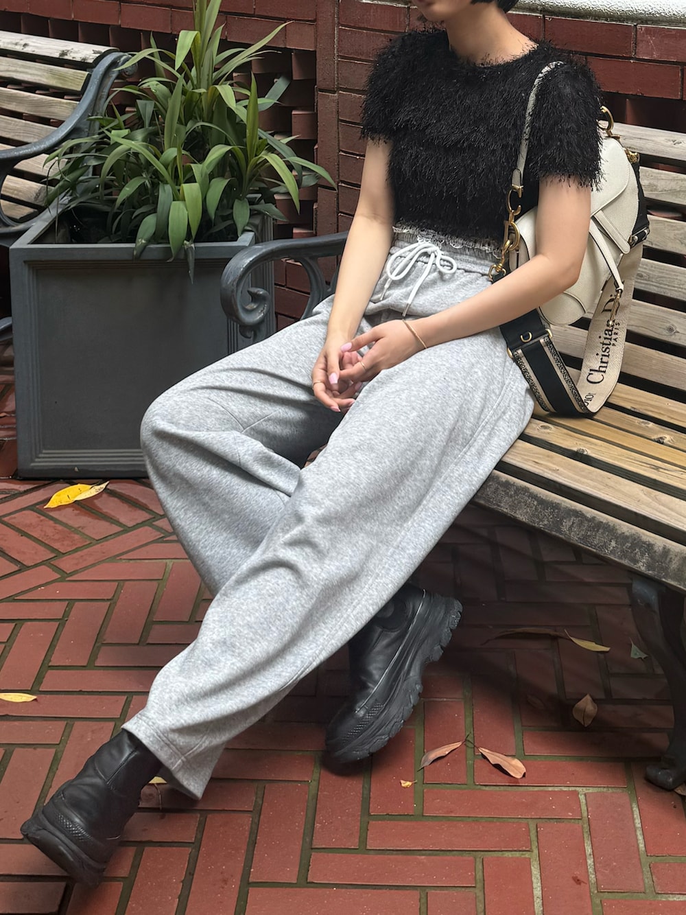 ブラック系のTシャツ/カットソー、グレー系のスウェットパンツ、ブラック系のスニーカーを着用したレディースの夏コーディネートの2枚目の写真