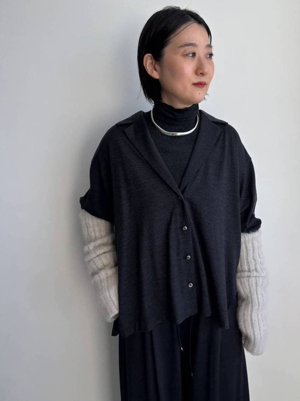 ブラック系のニット/セーター、グレー系のその他パンツ、グレー系のシャツ/ブラウスを着用したレディースの冬コーディネートの2枚目の写真