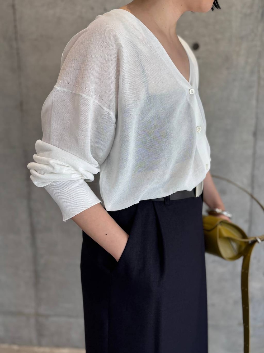 ホワイト系のカーディガン/ボレロ、ブルー系のスカート、ブラック系のベルトを着用したレディースの春コーディネートの7枚目の写真