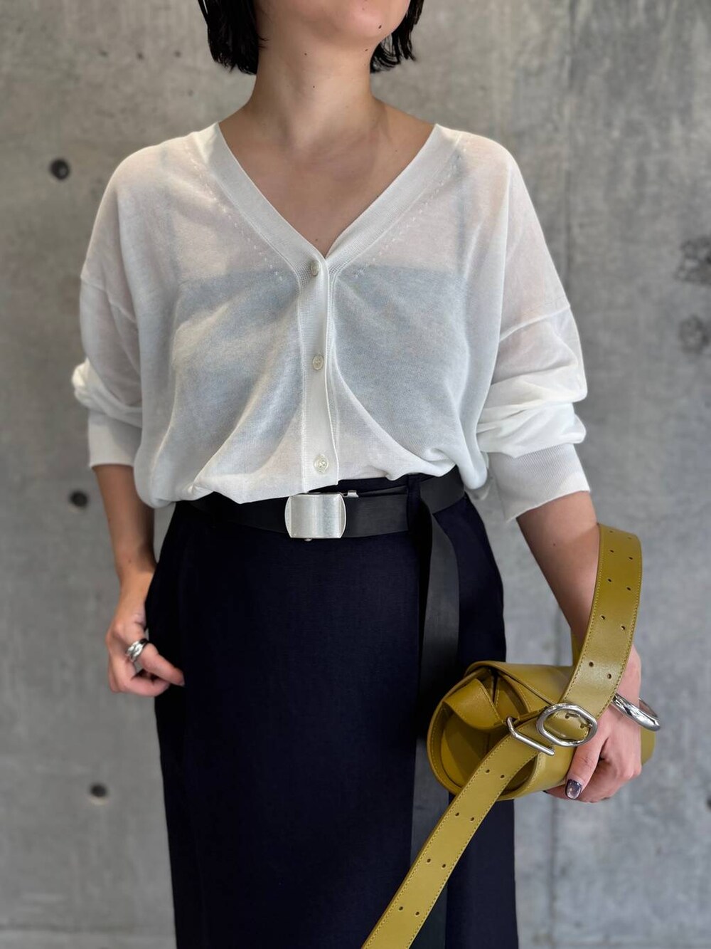 ホワイト系のカーディガン/ボレロ、ブルー系のスカート、ブラック系のベルトを着用したレディースの春コーディネートの6枚目の写真