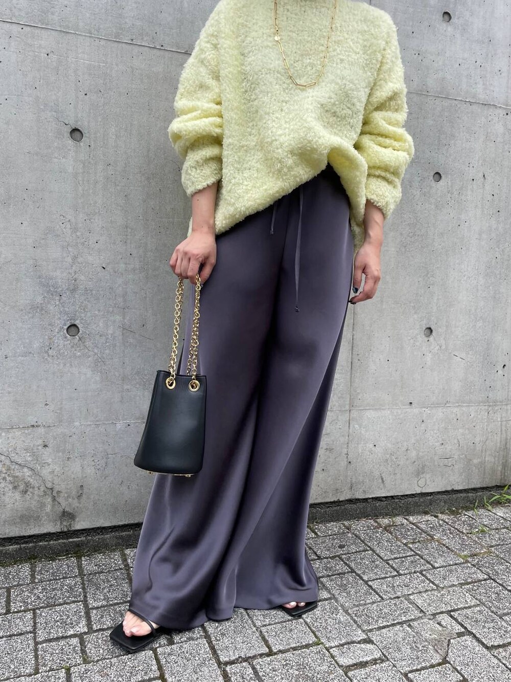 イエロー系のニット/セーター、グレー系のその他パンツを着用したレディースの夏コーディネートの5枚目の写真