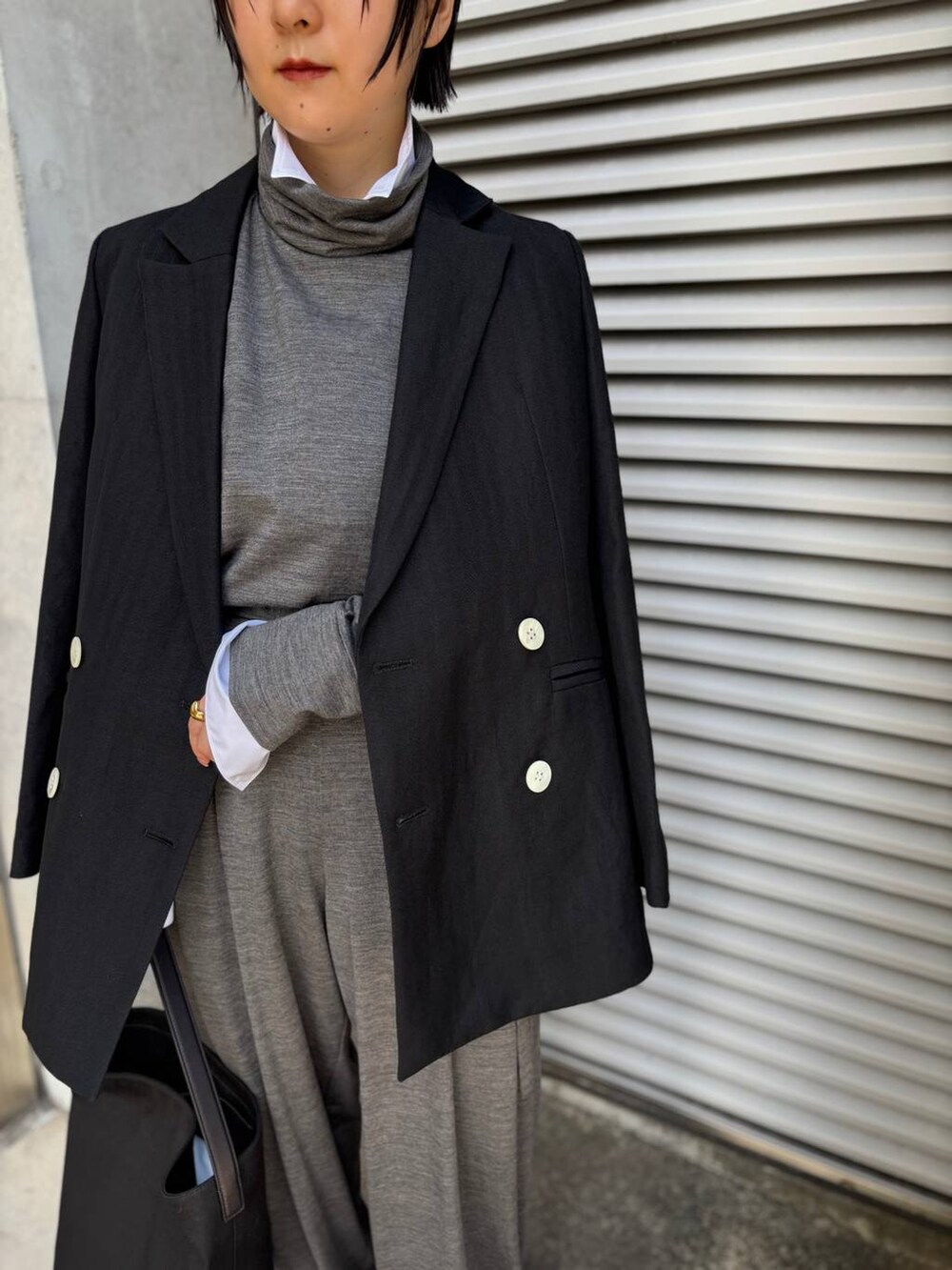 ブラック系のテーラードジャケット、ホワイト系のシャツ/ブラウス、グレー系のその他パンツを着用したレディースの秋コーディネートの7枚目の写真