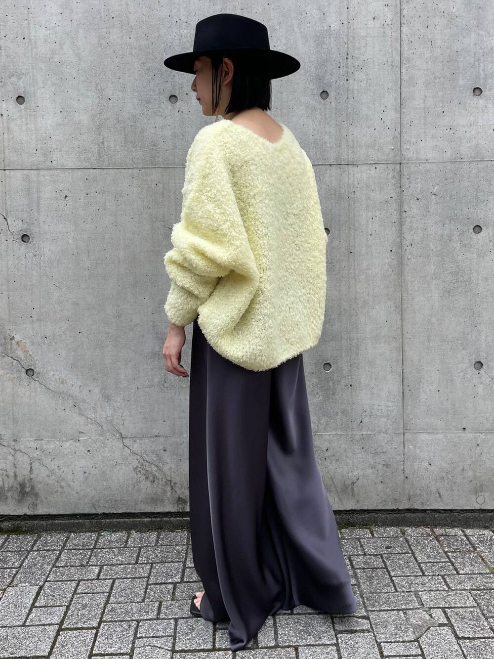 イエロー系のニット/セーター、グレー系のその他パンツを着用したレディースの夏コーディネートの4枚目の写真