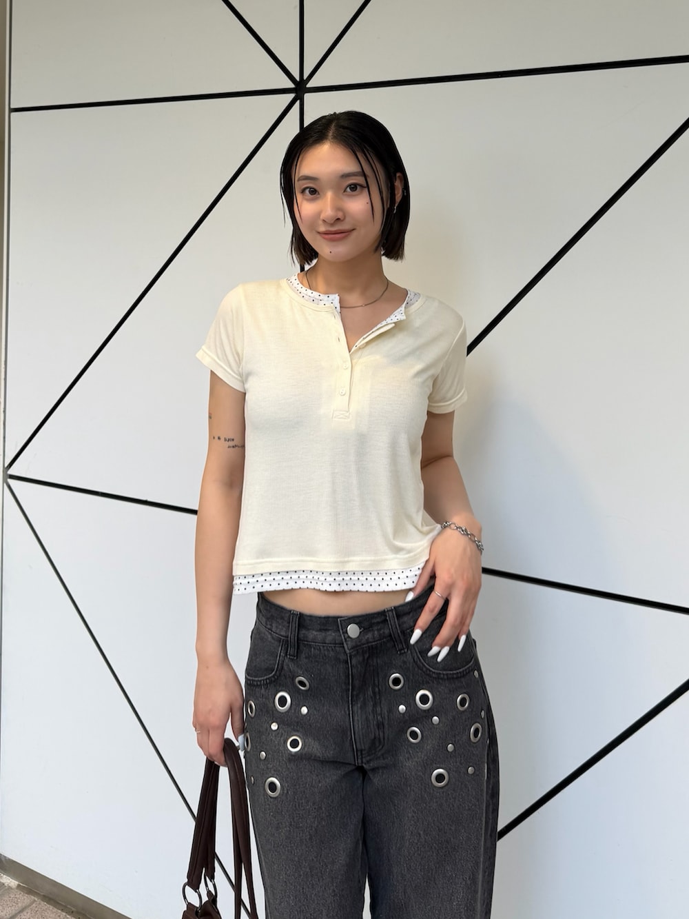 ホワイト系のTシャツ/カットソー、ブラック系のデニムパンツ、ブラウン系のショルダーバッグを着用したレディースの春コーディネートの2枚目の写真