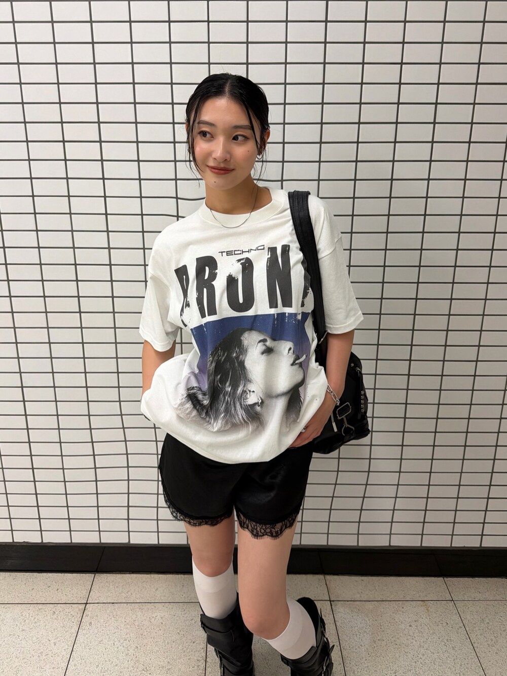 ホワイト系のTシャツ/カットソー、ブラック系のブーツ、ブラック系のショルダーバッグを着用したレディースの夏コーディネートの3枚目の写真