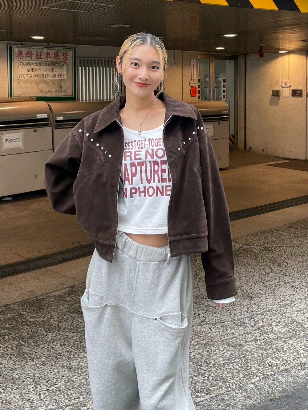 ブラウン系のブルゾン、ホワイト系のTシャツ/カットソー、グレー系のスウェットパンツを着用したレディースの秋コーディネートの3枚目の写真
