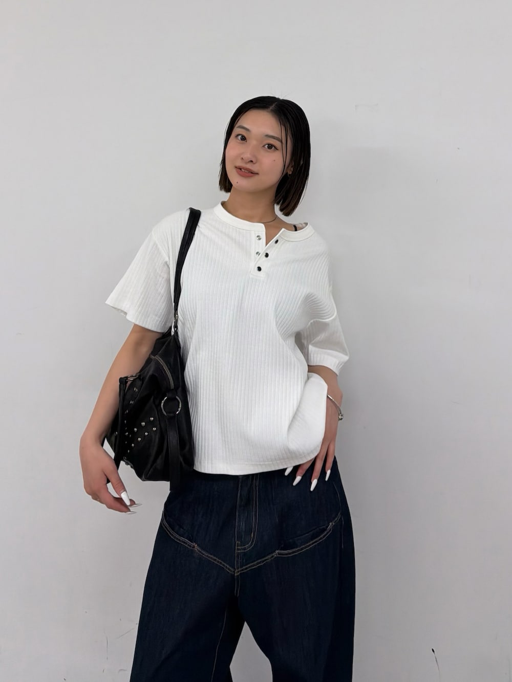 ホワイト系のTシャツ/カットソー、ブルー系のデニムパンツを着用したレディースの春コーディネートの2枚目の写真