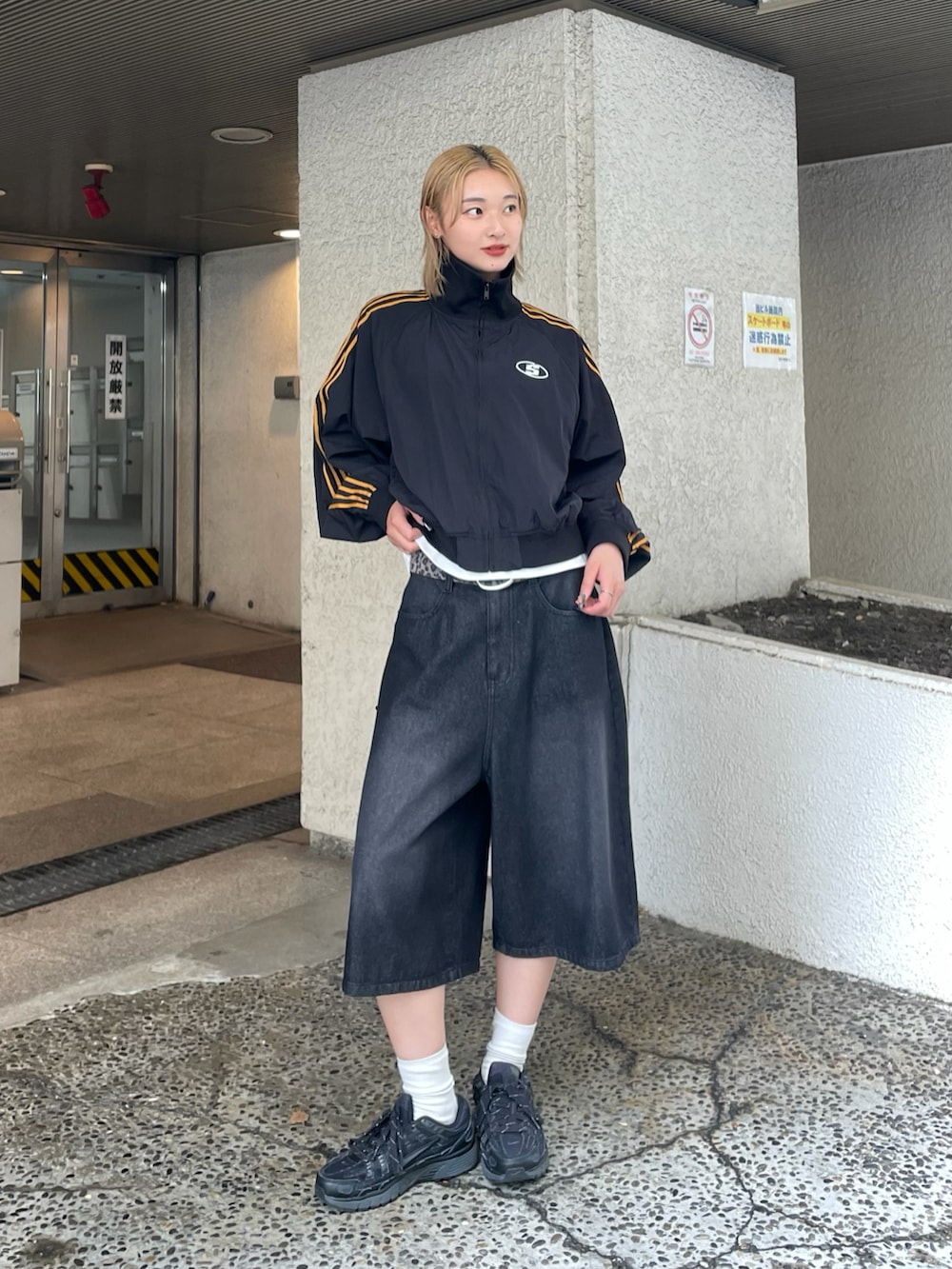 ブラック系のナイロンジャケット、ホワイト系のTシャツ/カットソー、ブラック系のデニムパンツを着用したレディースの夏コーディネートの2枚目の写真