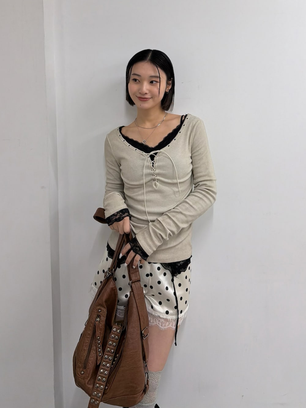 ホワイト系のTシャツ/カットソー、ホワイト系のその他パンツ、ブラック系のブーツを着用したレディースの春コーディネートの2枚目の写真