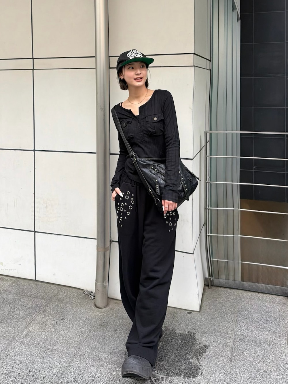 ブラック系のショルダーバッグ、ブラック系のスウェットパンツを着用したレディースの春コーディネートの2枚目の写真