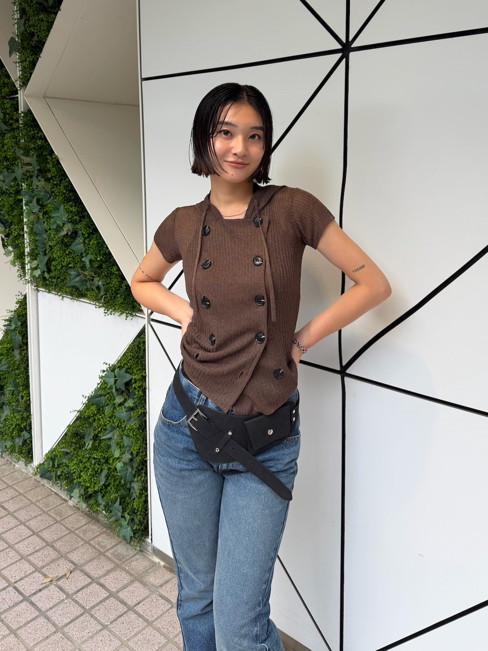 ブルー系のデニムパンツ、ブラック系のパンプス、ブラウン系のパーカーを着用したレディースの夏コーディネートの2枚目の写真