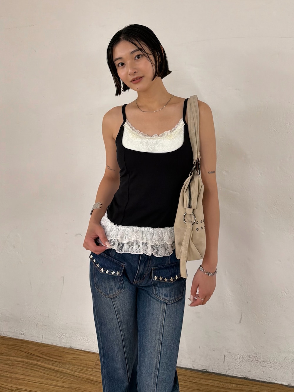 ブラック系のタンクトップ、ブルー系のデニムパンツ、ブラック系のパンプスを着用したレディースの夏コーディネートの2枚目の写真