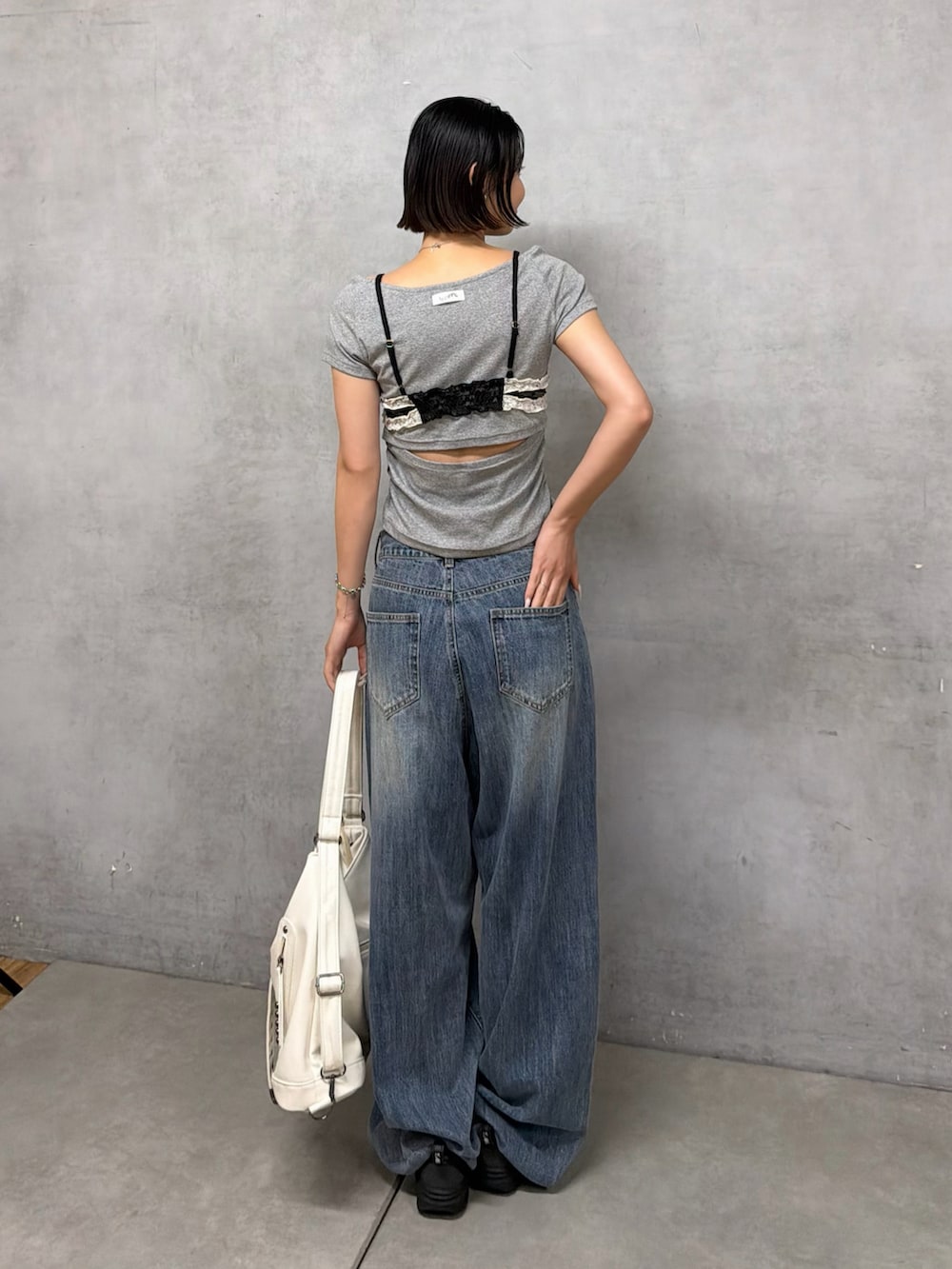 ホワイト系のショルダーバッグ、ブルー系のデニムパンツ、ブラック系のシャツ/ブラウスを着用したレディースの夏コーディネートの2枚目の写真