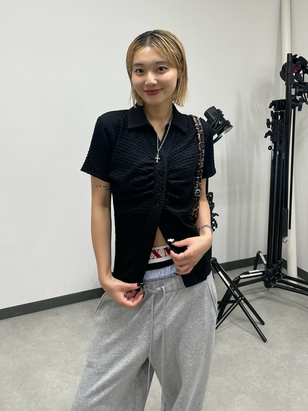 ブラック系のシャツ/ブラウス、グレー系のパンツ、ブラック系のパンプスを着用したレディースの夏コーディネートの2枚目の写真