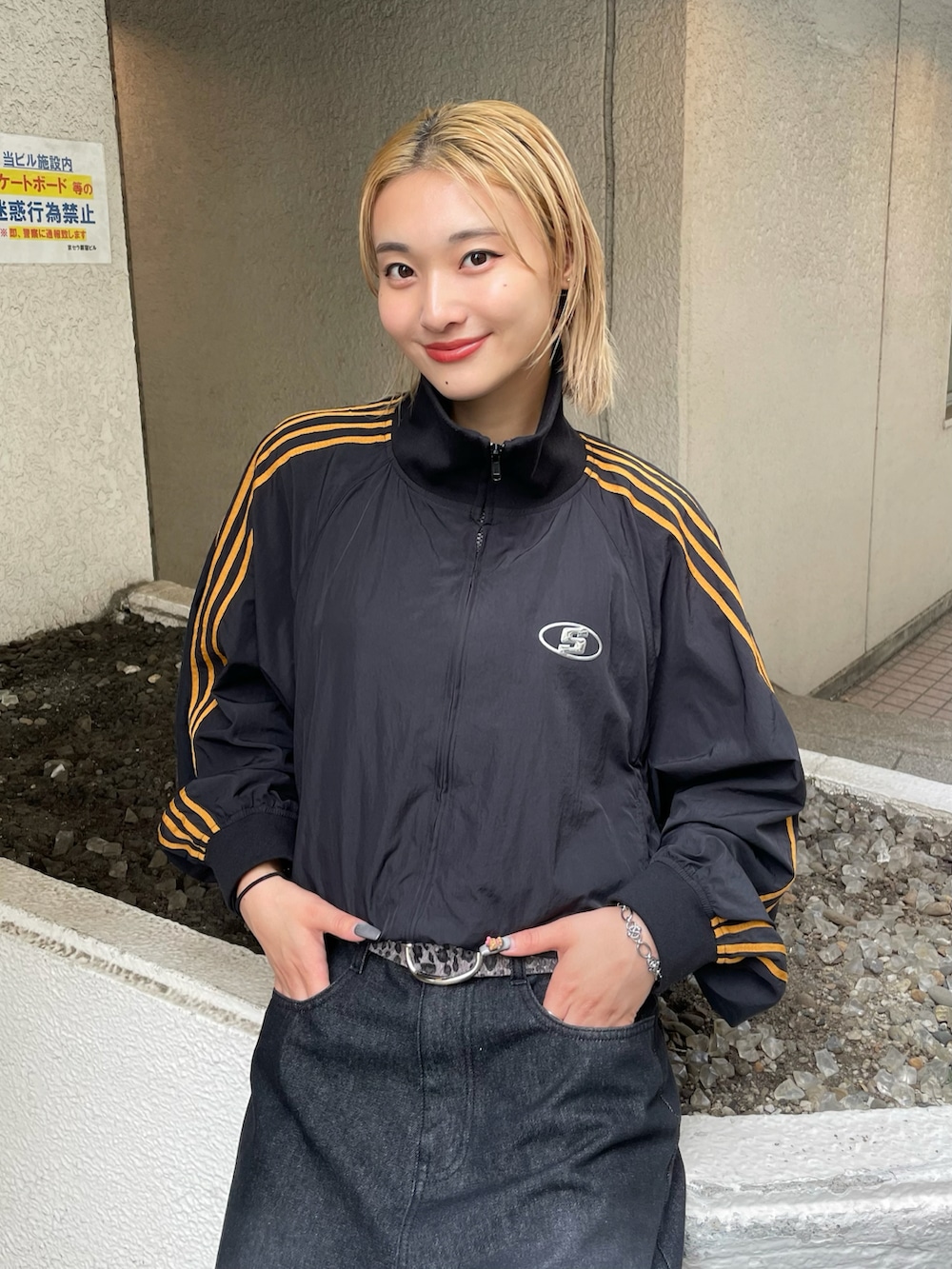 ブラック系のナイロンジャケット、ホワイト系のTシャツ/カットソー、ブラック系のデニムパンツを着用したレディースの夏コーディネートの3枚目の写真