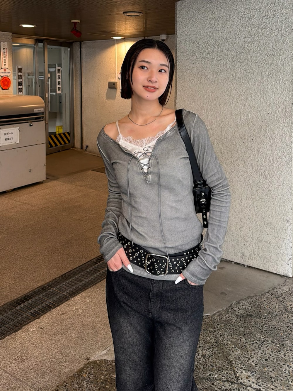 グレー系のTシャツ/カットソー、ブラック系のショルダーバッグ、ブラック系のデニムパンツを着用したレディースの春コーディネートの2枚目の写真