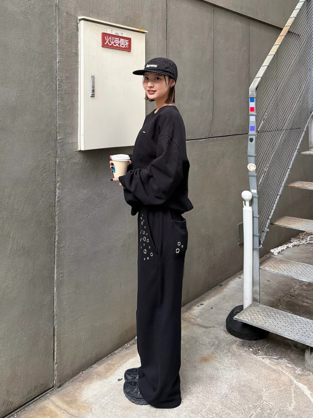 ブラック系のスウェットパンツを着用したレディースの春コーディネートの2枚目の写真