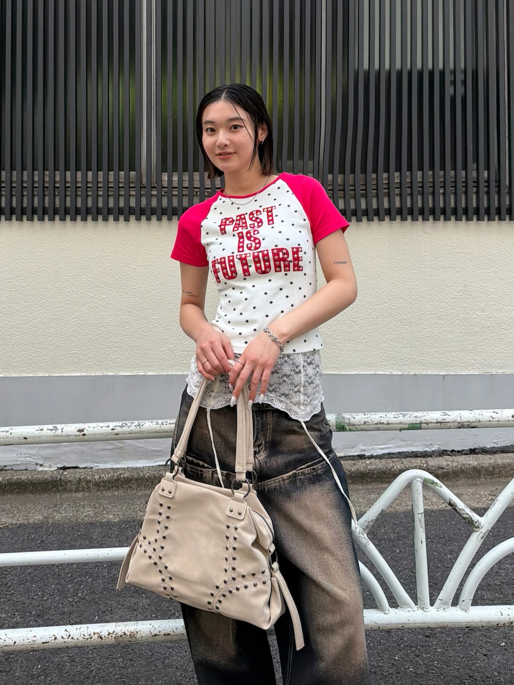 ブルー系のデニムパンツ、ピンク系のTシャツ/カットソー、ホワイト系のキャミソールを着用したレディースの春コーディネートの2枚目の写真