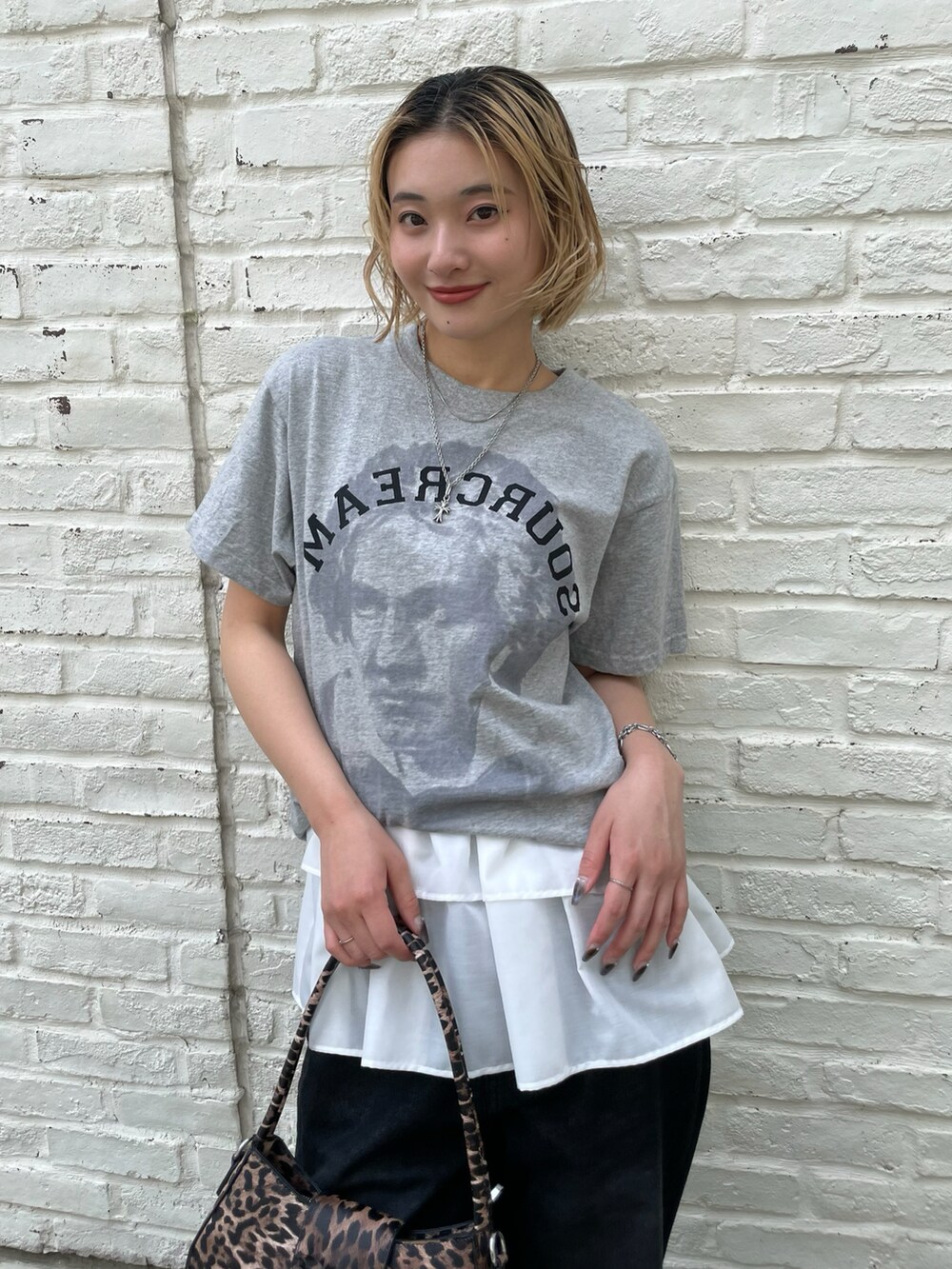 グレー系のTシャツ/カットソー、ホワイト系のキャミソール、ブラック系のデニムパンツを着用したレディースの春コーディネートの2枚目の写真