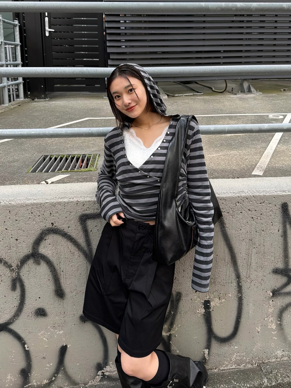 グレー系のパーカー、ホワイト系のキャミソールを着用したレディースの春コーディネートの3枚目の写真